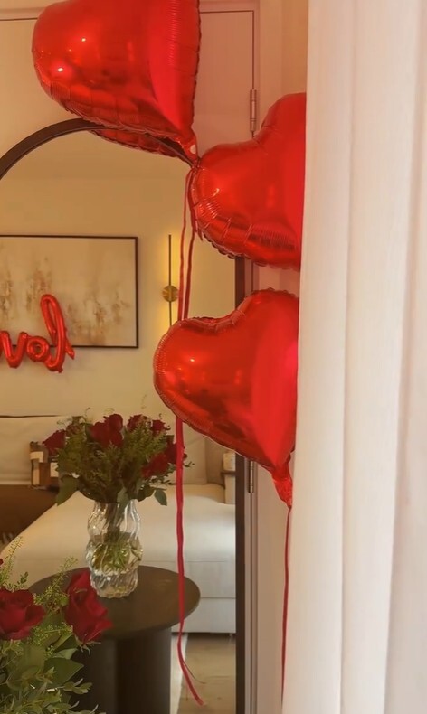 valentines at home ideas - living room with heart balloons and roses on wood side table