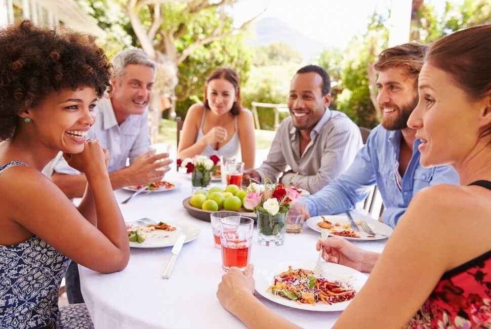 group of friends gathered around a round outdoor table