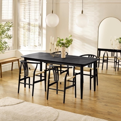 a modern black wooden dining table and chairs set in a warm and sunny modern dining room