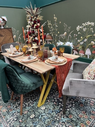 wooden trestle style dining table with gold legs, and green velvet dining chairs, dressed with Whimsical Woodland Christmas Decor 